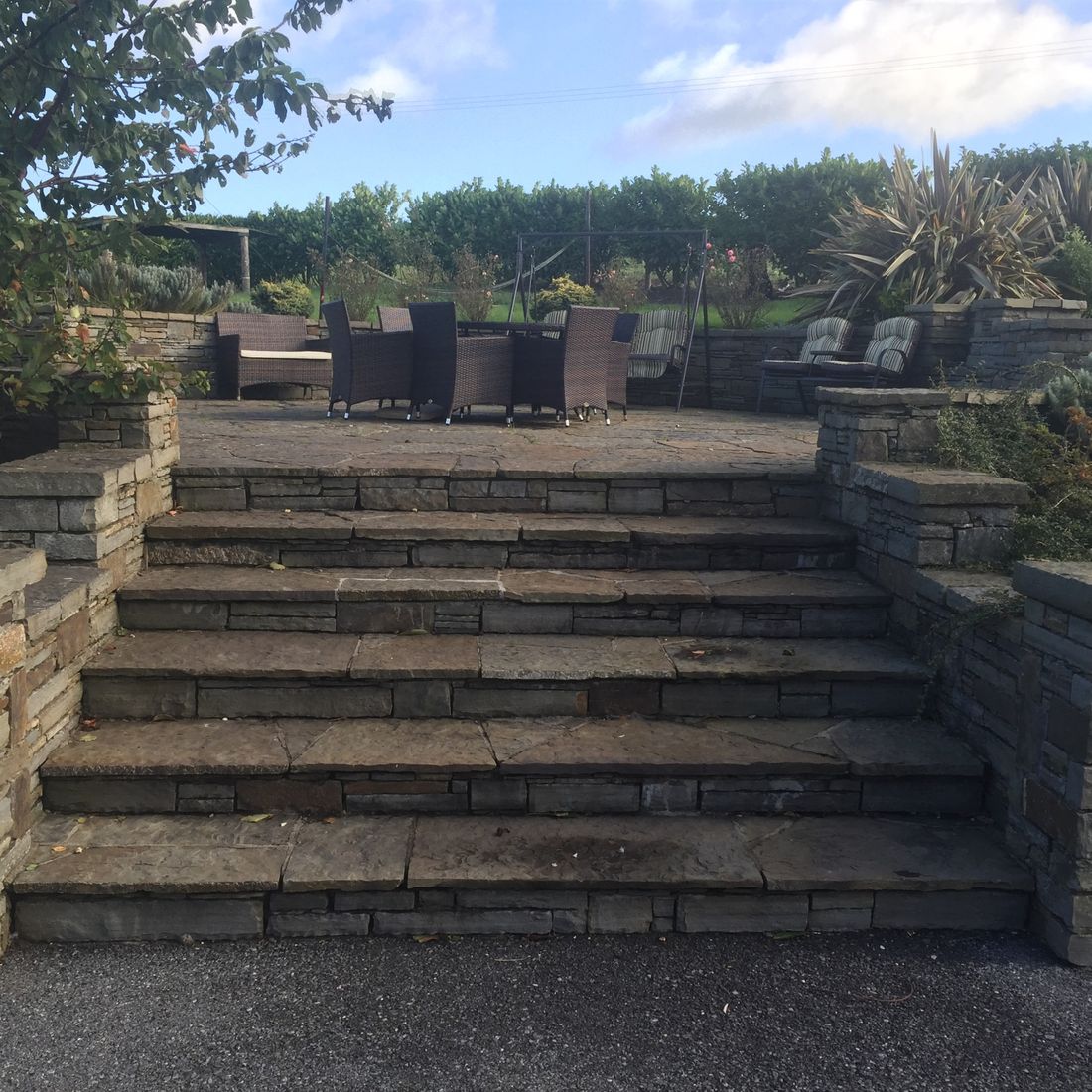 Random flagstone steps and patio complimented by grey sandstone