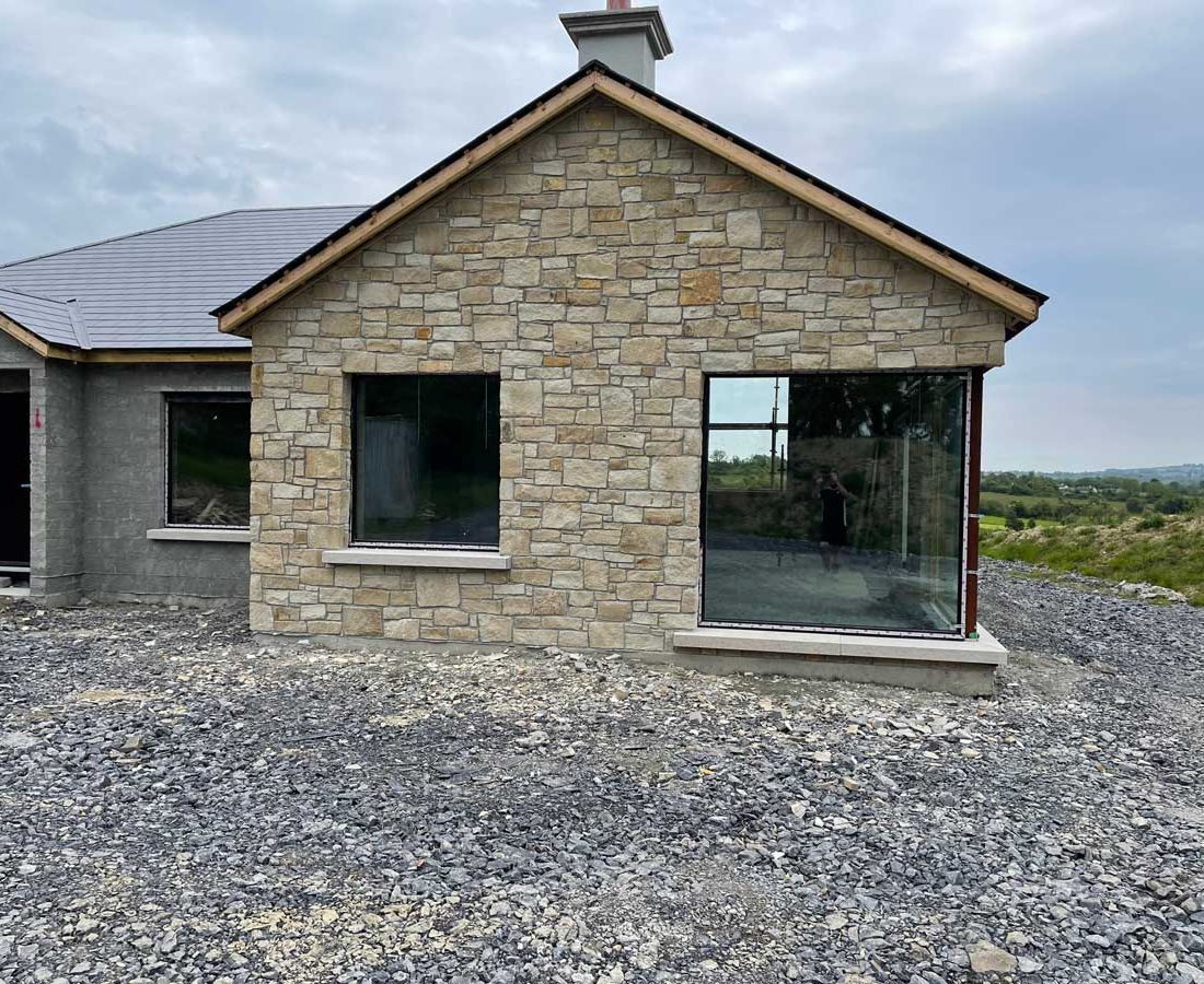 Dressed cream sandstone complimented with grey granite window cills 