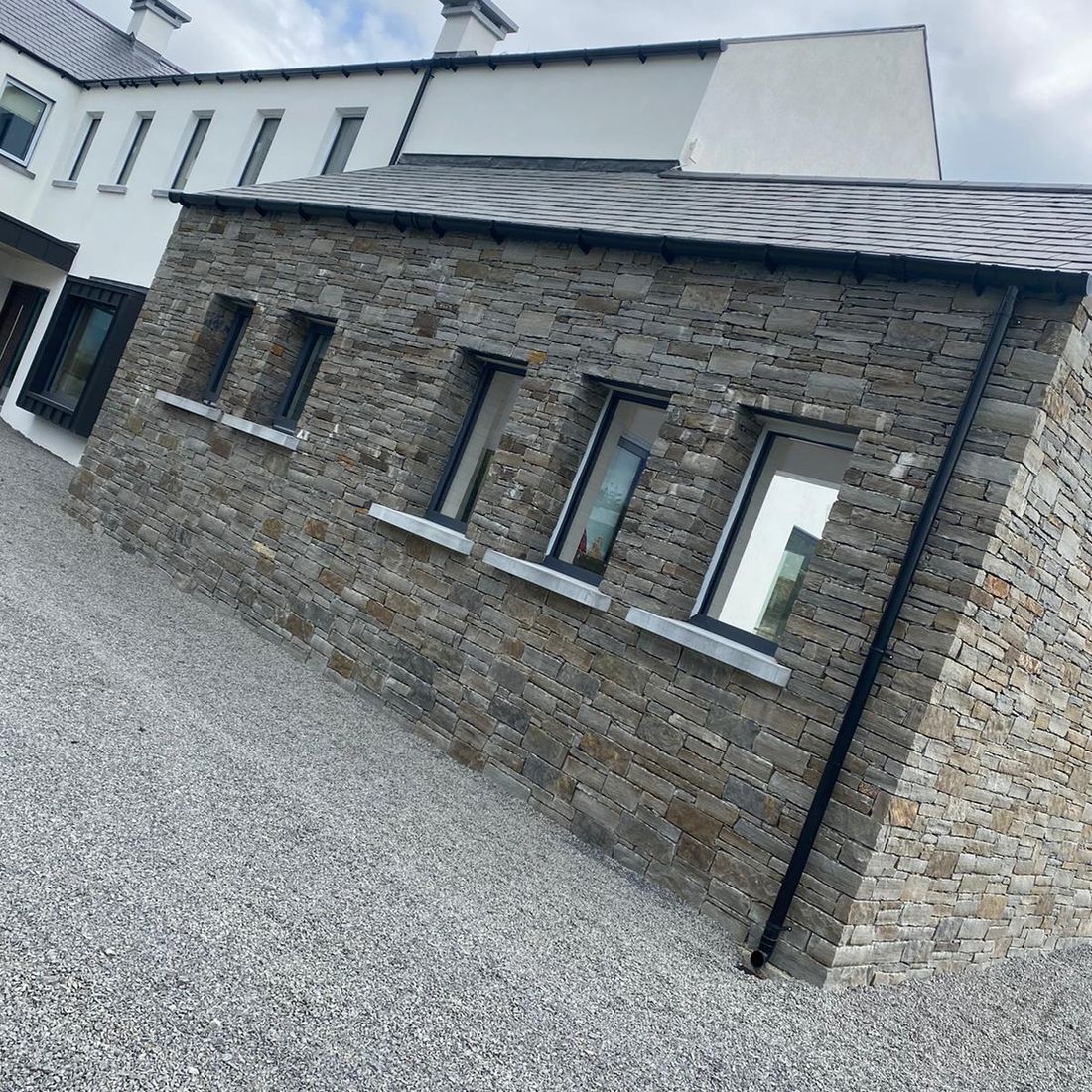 Rustic brown sandstone complimented with sanded limestone cills