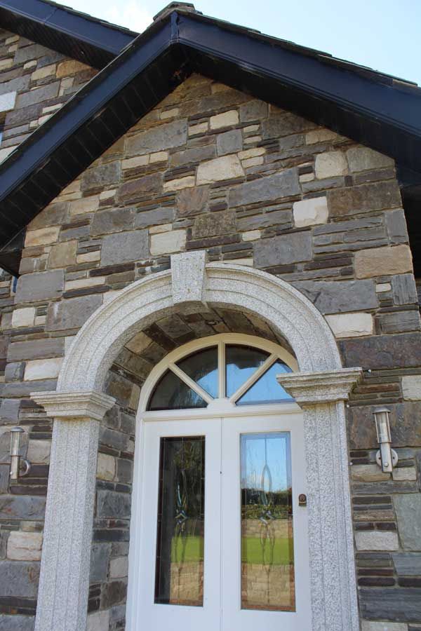 Grey, brown & cream sandstone mixed enhanced with grey granite door surround