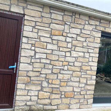 Cream sandstone thin stone cladding enhanced using a grey pointed joint