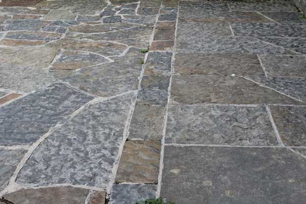 Random grey & brown sandstone paving complimented with cut regular paving path