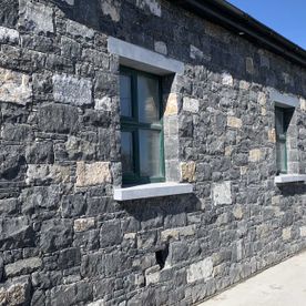 Random white limestone with a variety of natural shades enhanced with limestone heads & cills
