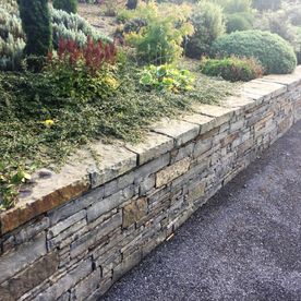 Dressed grey sandstone wall capping complimenting retaining wall