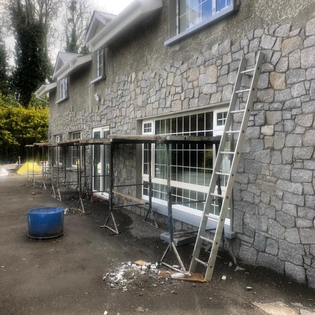 Dwelling house being fitted with random granite thin wall cladding 