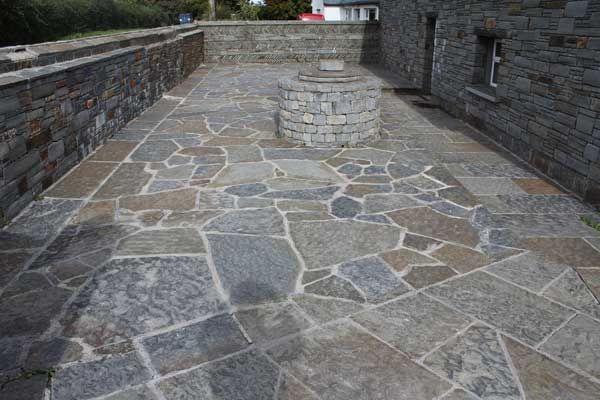 Random grey brown paving with a selection of grey brown walling