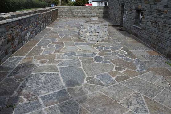 Random grey & brown sandstone paving complimented with cut regular paving