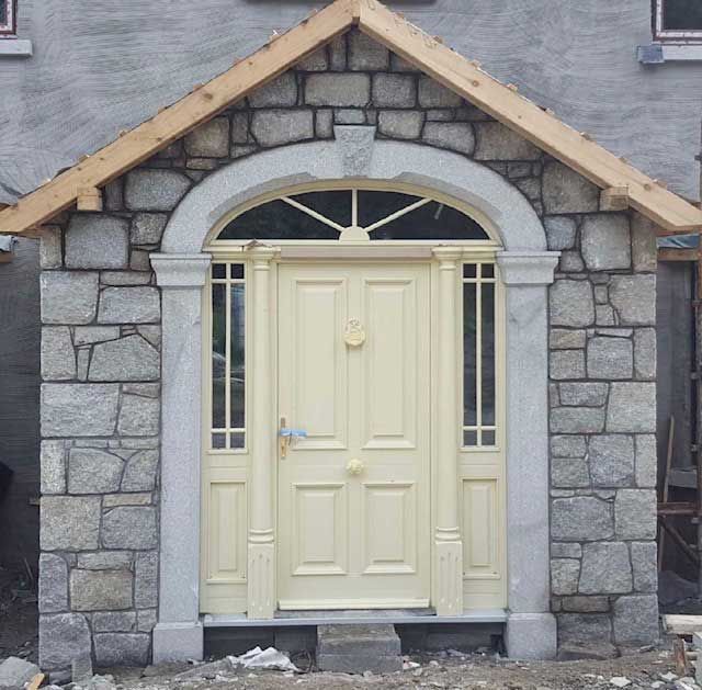 Grey granite laid in traditional courses complemented with cut grey granite arch